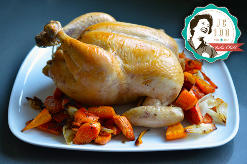 A side view of Julia Child's classic roast chicken recipe on a platter with roasted vegetables.