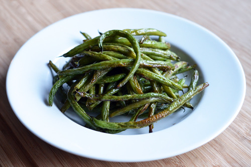A platter of roasted green beans in a white plate.