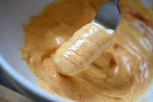 The mayonnaise mixture of smoked paprika and tabasco in a bowl, mixed together.