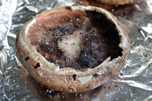A seasoned portobello mushroom ready for the oven.