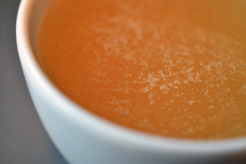 A close up of beef bone broth heated up in a cup.