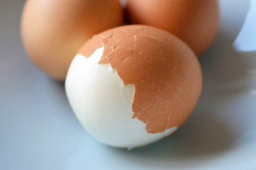 A half peeled perfectly hard-boiled egg.