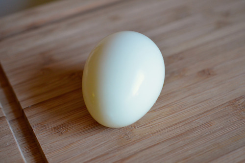 A hard-boiled egg on a cutting board.
