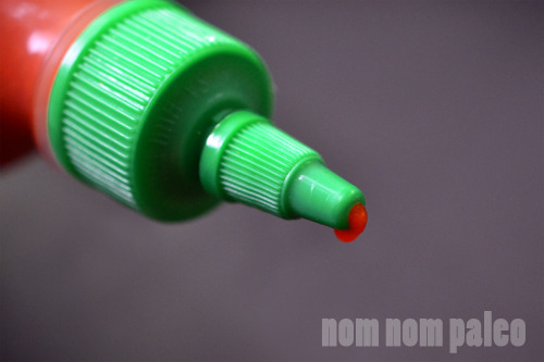 A closeup of the green tip of commercial sriracha
