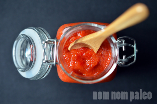 An overhead shot of Paleo Sriracha in a jar with a wooden spoon inside.
