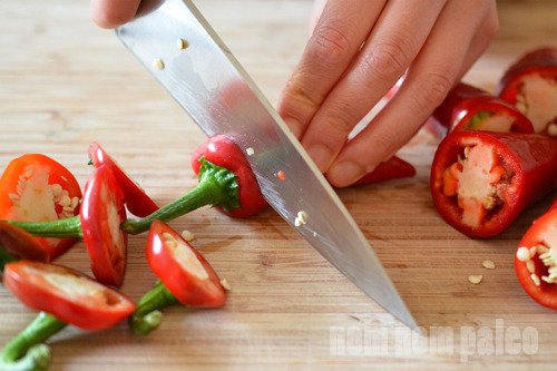 Cutting the tops off of red jalapeños for Paleo Sriracha