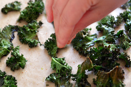 Once the baked kale chips are out of the oven, season them with some fleur de sel, Magic Mushroom Powder, nutritional yeast, or your favorite seasoning salt.