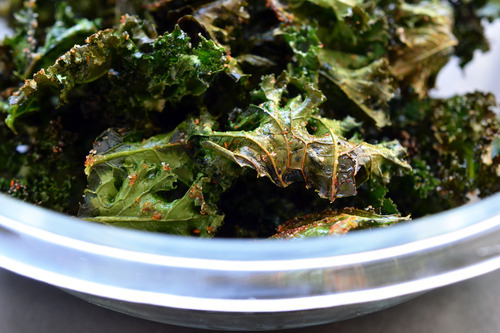 A bowl of baked kale chips that is ready to eat! A perfect healthy snack for kids and adults!